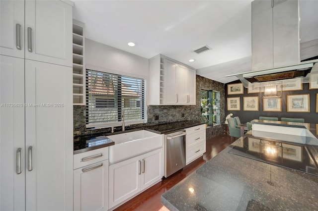 kitchen featuring white cabinetry, island range hood, stainless steel dishwasher, dark hardwood / wood-style floors, and dark stone counters