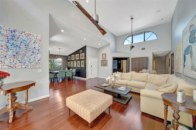 living room featuring dark wood-type flooring, a high ceiling, and a wealth of natural light