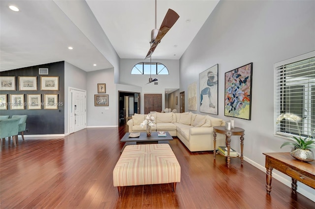 living room with a high ceiling and dark hardwood / wood-style flooring