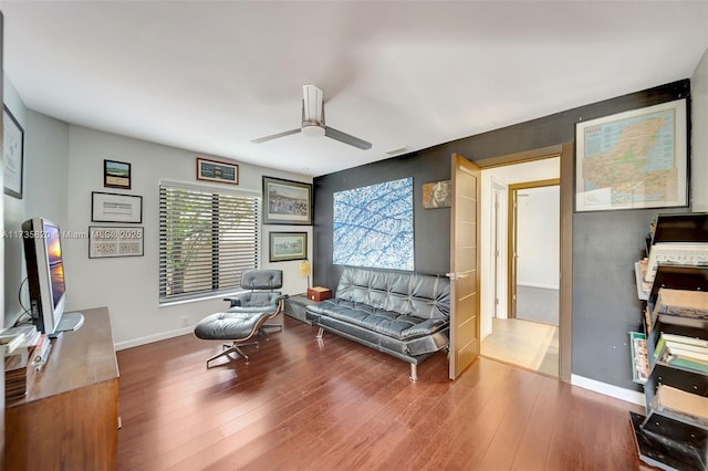 sitting room with ceiling fan and hardwood / wood-style floors