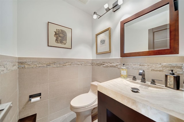 bathroom with vanity, tile walls, and toilet