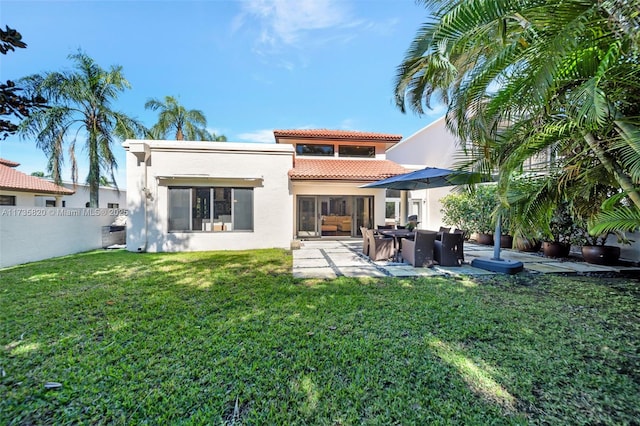 rear view of property featuring a yard and a patio