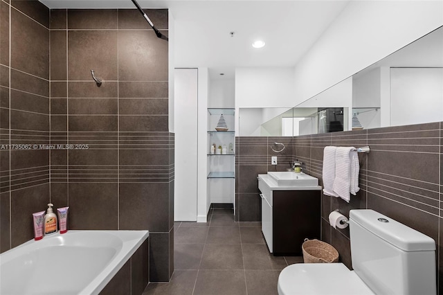 bathroom featuring vanity, a tub, tile walls, and toilet