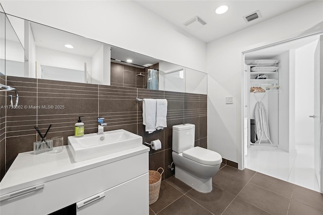 bathroom featuring tile patterned floors, toilet, a shower with curtain, tile walls, and vanity