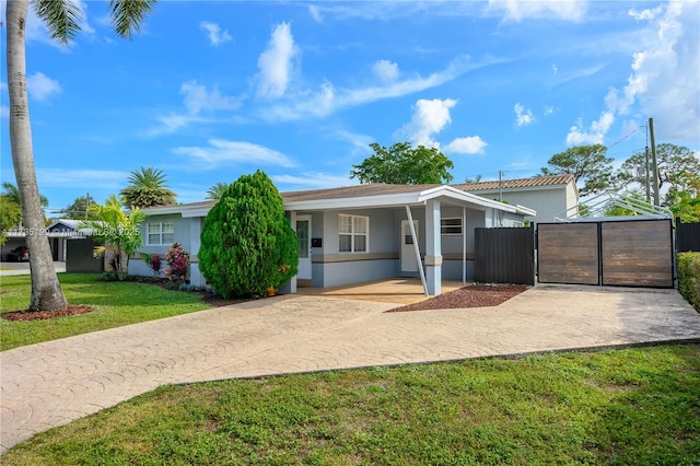 1498 NE 39th St, Oakland Park, FL 33334 - ranch-style home with driveway, a gate, stucco siding, and a carport