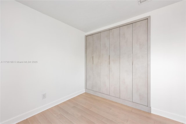 1498 NE 39th St, Oakland Park, FL 33334 - unfurnished bedroom featuring light wood-style flooring, baseboards, and a closet