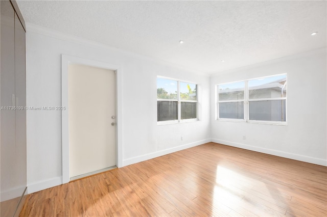 1498 NE 39th St, Oakland Park, FL 33334 - spare room with light wood finished floors, crown molding, a textured ceiling, and baseboards