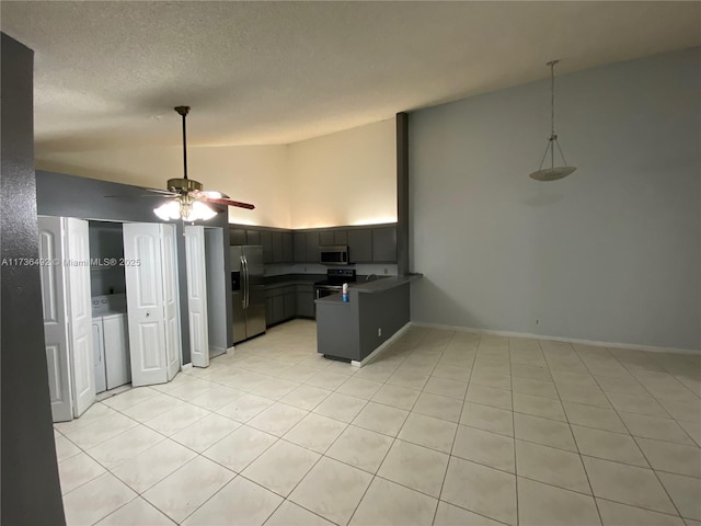 kitchen with ceiling fan, appliances with stainless steel finishes, a textured ceiling, vaulted ceiling, and kitchen peninsula