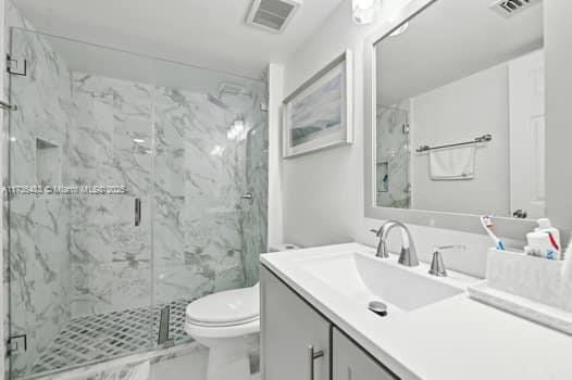 bathroom with vanity, an enclosed shower, and toilet