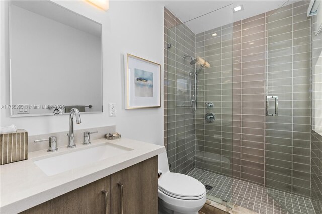 bathroom featuring vanity, an enclosed shower, and toilet