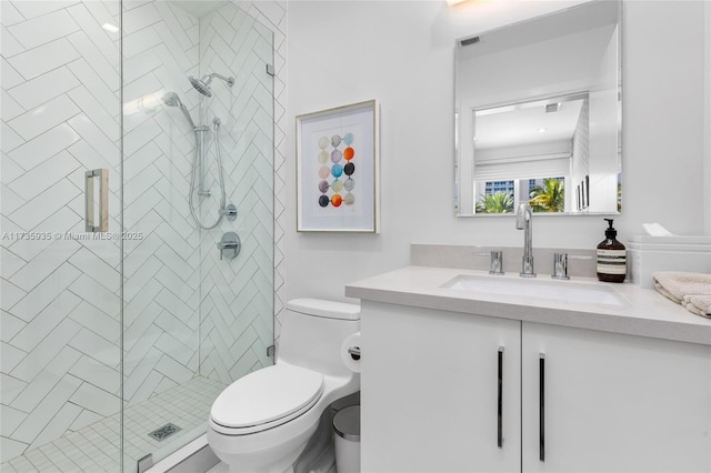 bathroom featuring vanity, toilet, and a shower with shower door