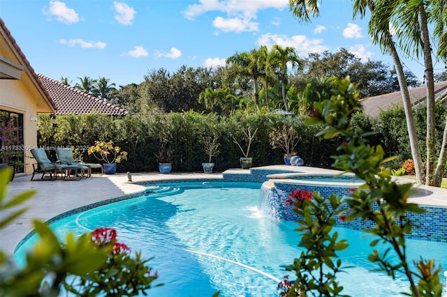 view of swimming pool featuring an in ground hot tub and a patio area