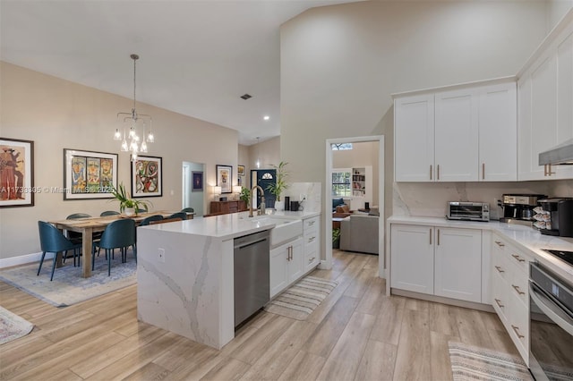 kitchen featuring appliances with stainless steel finishes, sink, hanging light fixtures, and white cabinets