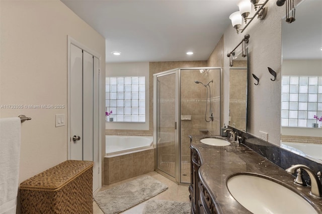 bathroom featuring tile patterned flooring, vanity, and shower with separate bathtub