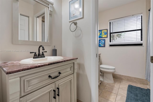 bathroom featuring tile patterned flooring, vanity, and toilet