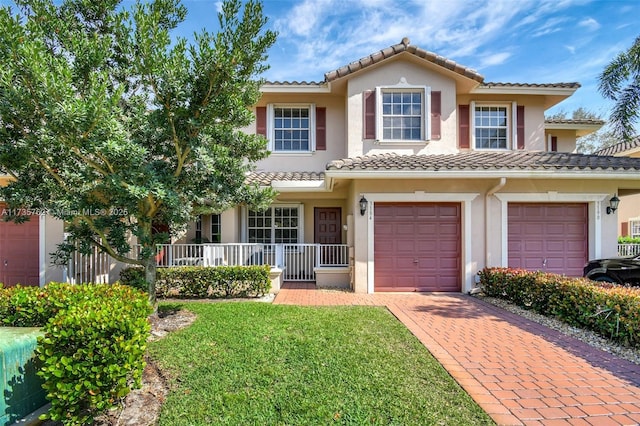 mediterranean / spanish house with a garage and a front lawn