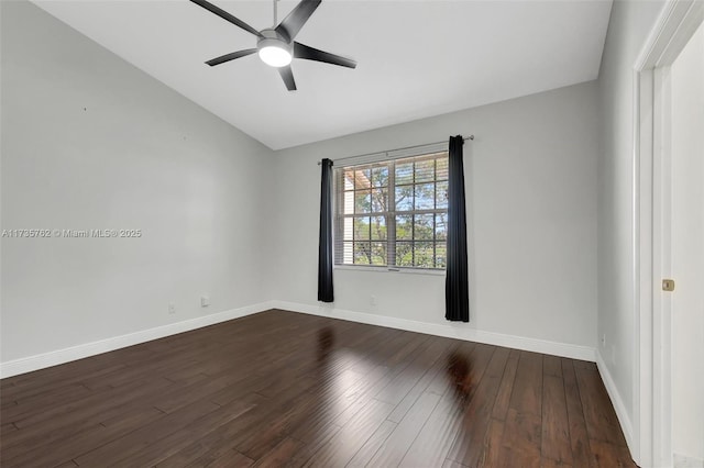 empty room with vaulted ceiling, ceiling fan, and dark hardwood / wood-style flooring