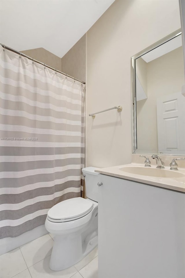 bathroom with vanity, vaulted ceiling, tile patterned floors, and toilet