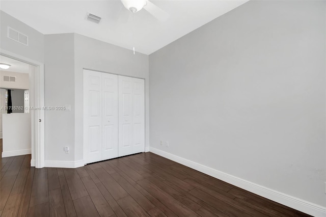 unfurnished bedroom featuring dark wood-type flooring, ceiling fan, and a closet