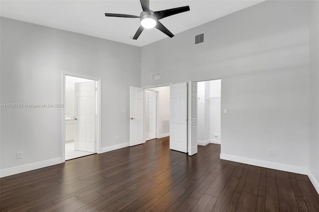 unfurnished bedroom with connected bathroom, high vaulted ceiling, dark hardwood / wood-style flooring, a closet, and ceiling fan