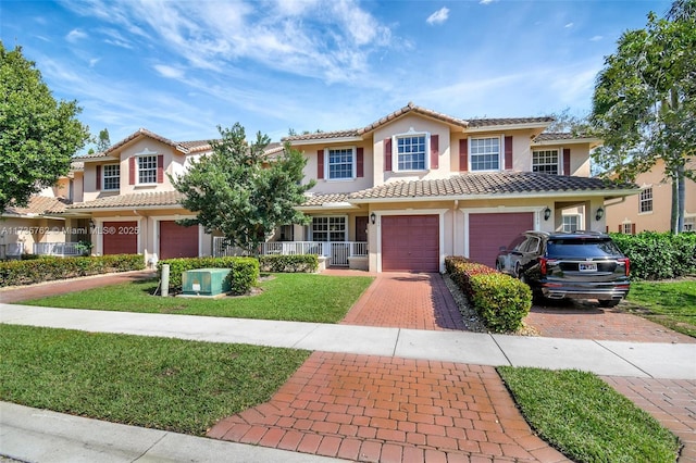 mediterranean / spanish-style home with a garage, covered porch, and a front lawn