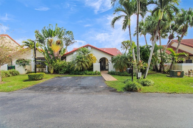 mediterranean / spanish house with central AC unit and a front lawn