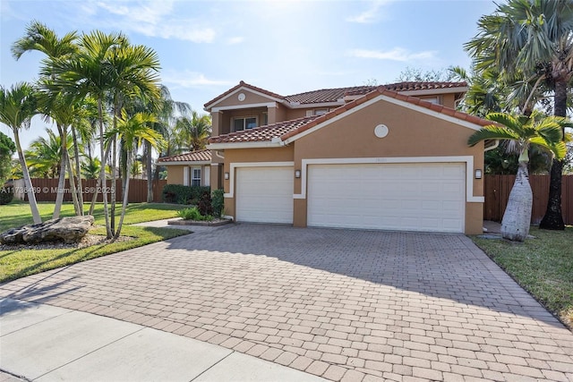 mediterranean / spanish home with a garage and a front lawn