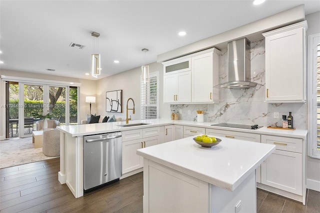 kitchen with decorative light fixtures, white cabinetry, dishwasher, kitchen peninsula, and wall chimney range hood