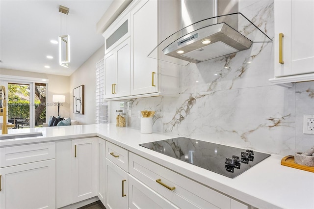 kitchen with pendant lighting, island exhaust hood, black electric stovetop, decorative backsplash, and white cabinets