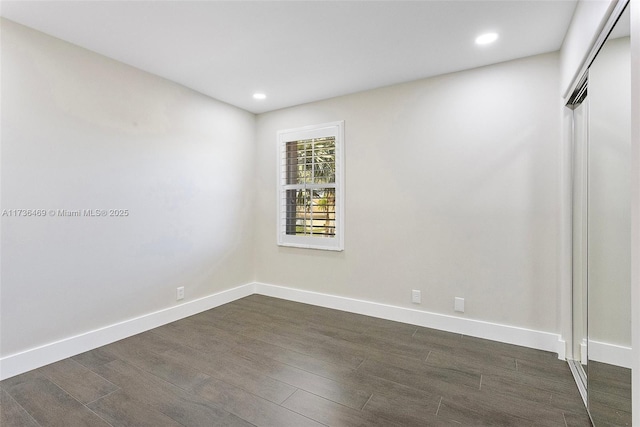 unfurnished room with dark wood-type flooring