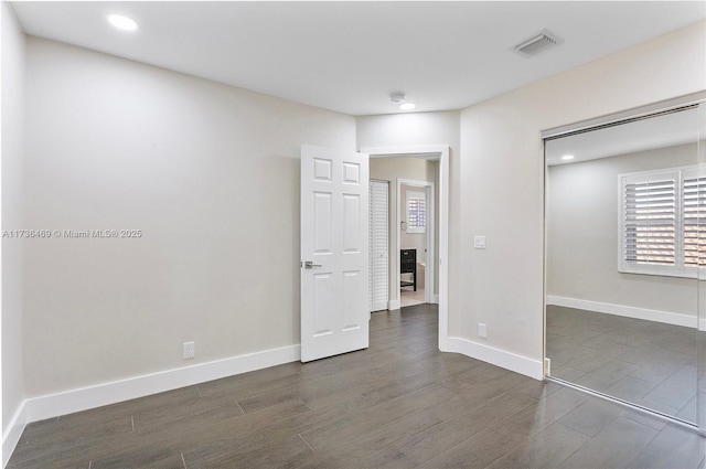 unfurnished bedroom featuring dark hardwood / wood-style flooring and a closet