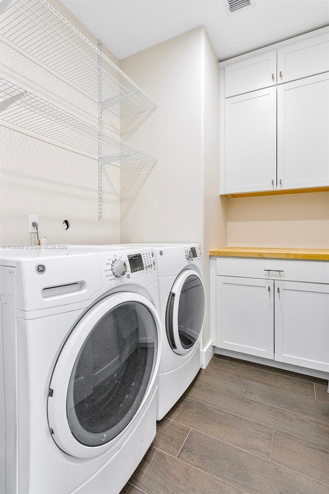 washroom featuring cabinets and washer and dryer