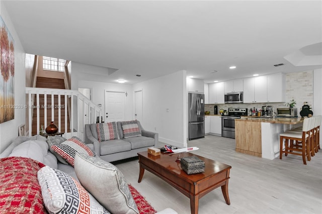 living room featuring light hardwood / wood-style floors and sink