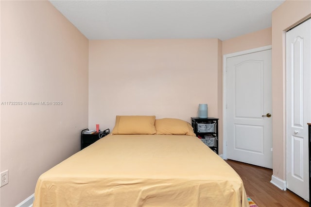 bedroom with dark wood-type flooring