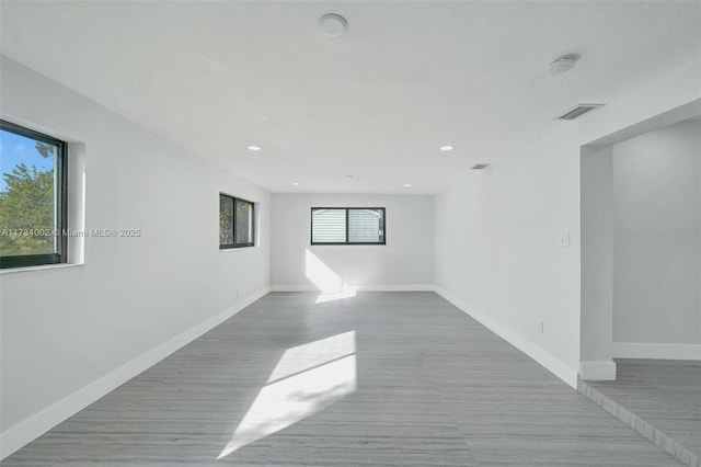 unfurnished room with a healthy amount of sunlight and light hardwood / wood-style flooring