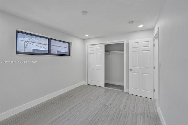 unfurnished bedroom with a closet and light wood-type flooring