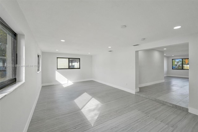 spare room featuring a healthy amount of sunlight and light hardwood / wood-style floors