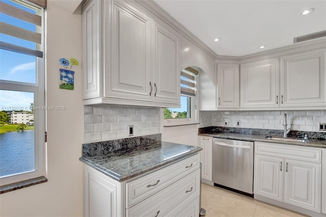 kitchen with sink, white cabinetry, tasteful backsplash, dishwasher, and dark stone counters