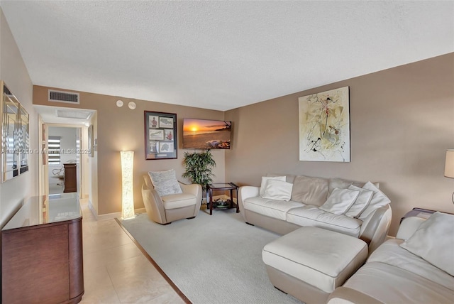 living room with light tile patterned flooring and a textured ceiling