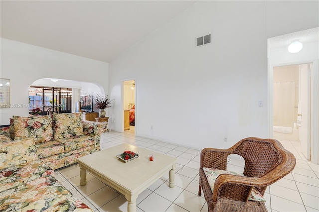 living room with light tile patterned floors and high vaulted ceiling