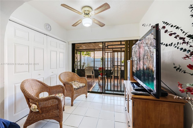 living area with light tile patterned floors and ceiling fan