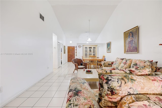 living room with light tile patterned floors and high vaulted ceiling