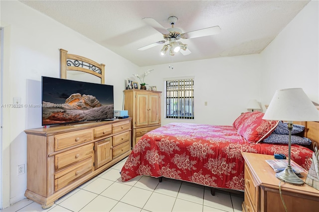 tiled bedroom featuring ceiling fan and a textured ceiling