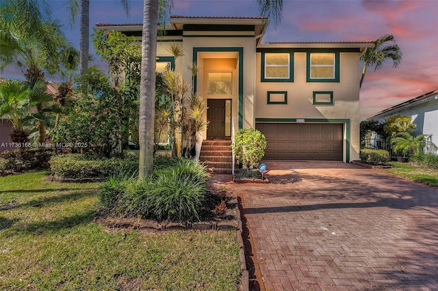 mediterranean / spanish-style home featuring a garage and a lawn