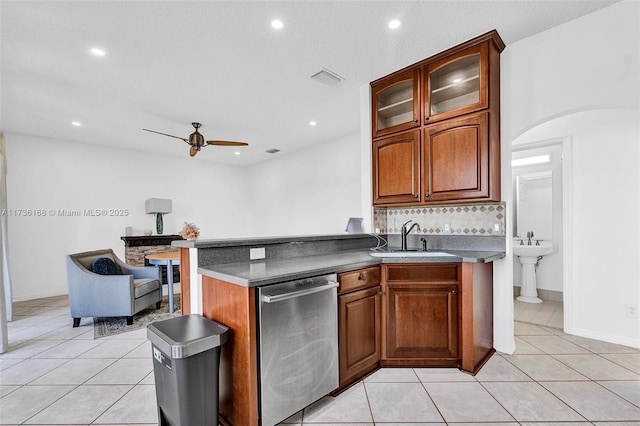 kitchen featuring light tile patterned flooring, sink, stainless steel dishwasher, ceiling fan, and decorative backsplash