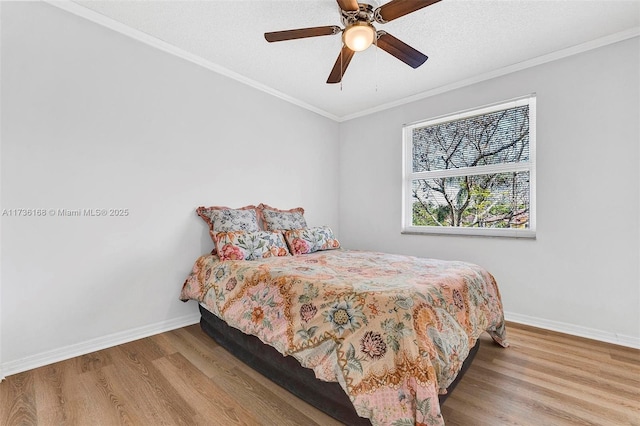 bedroom with crown molding, a textured ceiling, ceiling fan, and light hardwood / wood-style floors