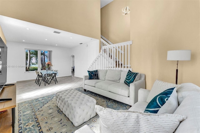 living room with tile patterned flooring and a high ceiling