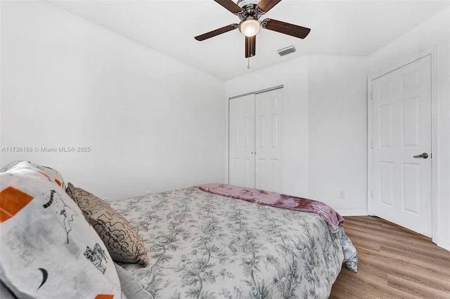 bedroom with hardwood / wood-style flooring, ceiling fan, and a closet