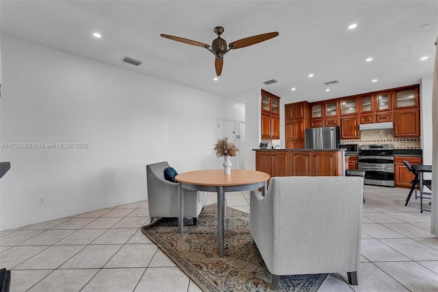 tiled dining space with ceiling fan