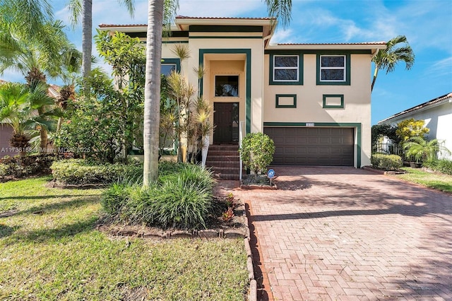 mediterranean / spanish-style home featuring a garage and a front yard